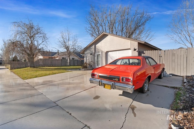 view of side of property featuring a garage and a lawn