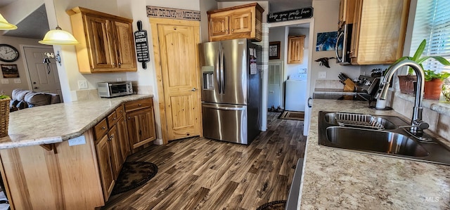110 Memory Ln, Kamiah, ID 83536 - kitchen featuring stainless steel fridge with ice dispenser, a sink, a peninsula, dark wood-style floors, and washer / dryer