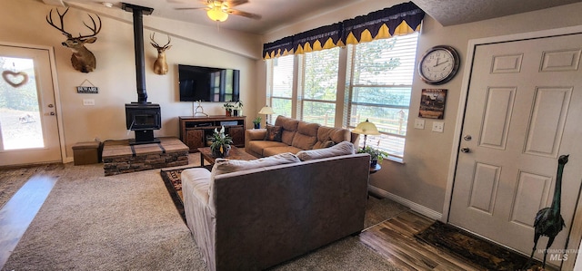 110 Memory Ln, Kamiah, ID 83536 - living area featuring a wood stove, a ceiling fan, baseboards, and dark wood-style floors