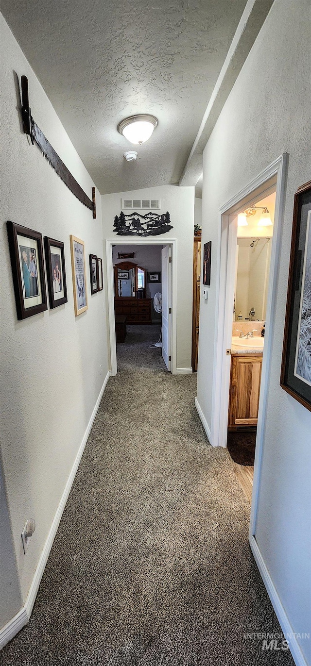 110 Memory Ln, Kamiah, ID 83536 - hallway featuring a textured ceiling, carpet, baseboards, and a sink
