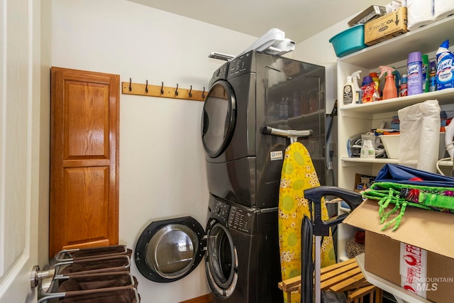 clothes washing area featuring stacked washer and clothes dryer