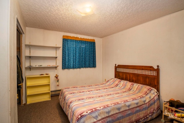 bedroom with a textured ceiling, dark colored carpet, and a baseboard heating unit