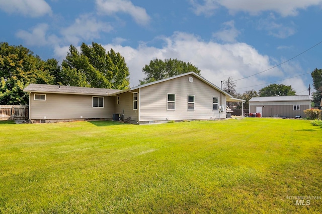 rear view of house featuring a yard and central AC unit