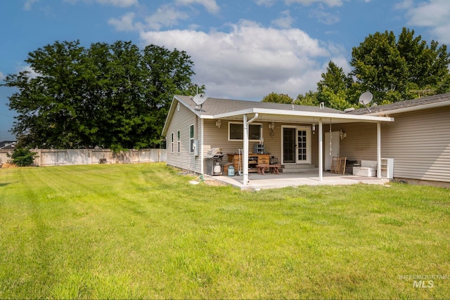 back of property with a lawn and a patio area