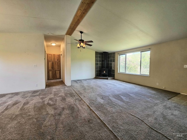 unfurnished living room with a wood stove, carpet flooring, and a ceiling fan