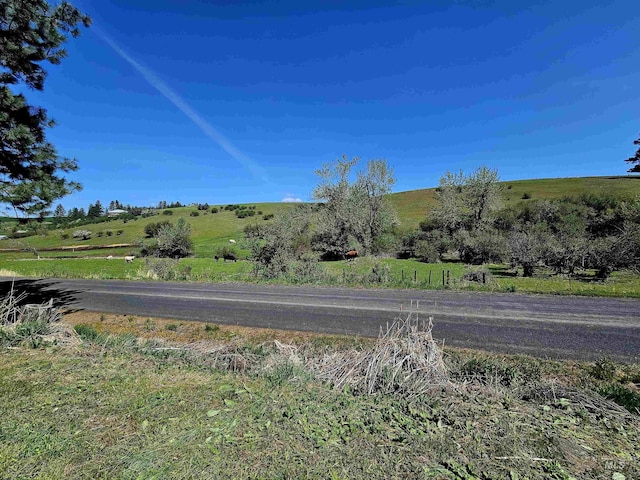 view of asphalt street featuring a view of countryside