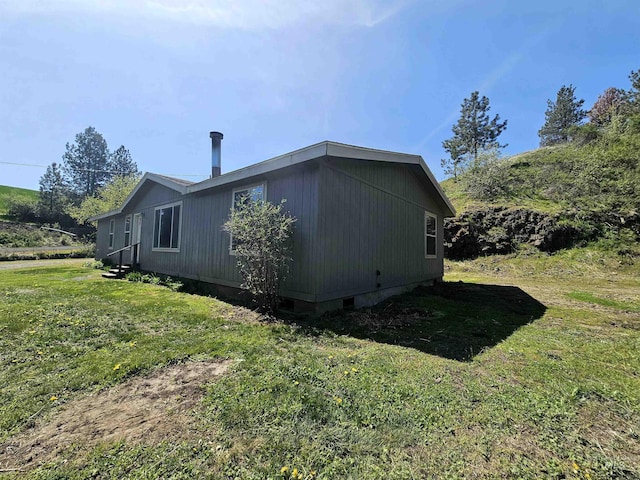 view of side of home with a yard