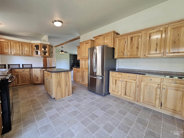 kitchen with freestanding refrigerator, a ceiling fan, black electric range, a center island, and glass insert cabinets
