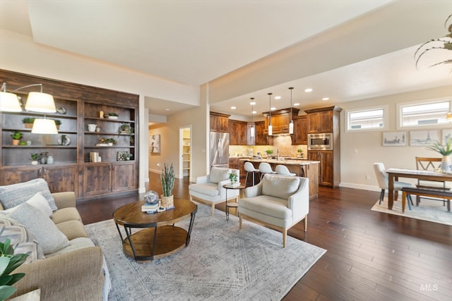 living area with recessed lighting, baseboards, and dark wood-type flooring