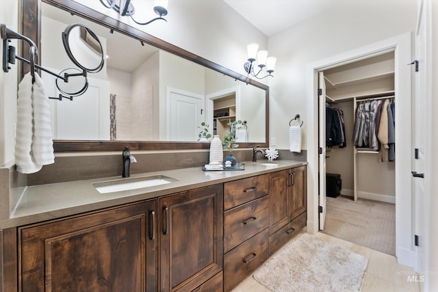 bathroom with a spacious closet, tile patterned flooring, double vanity, and a sink