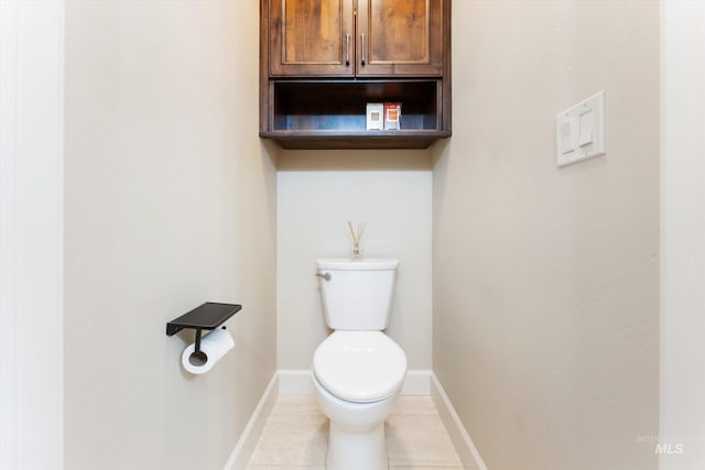 bathroom with tile patterned floors, baseboards, and toilet