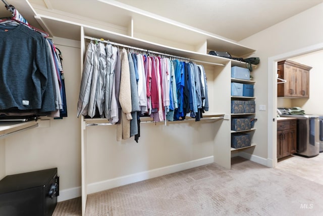 walk in closet with light carpet and washer / clothes dryer