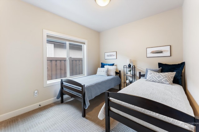 bedroom featuring light colored carpet and baseboards