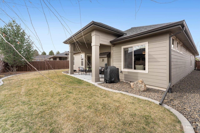 rear view of property with a patio area, a lawn, and fence