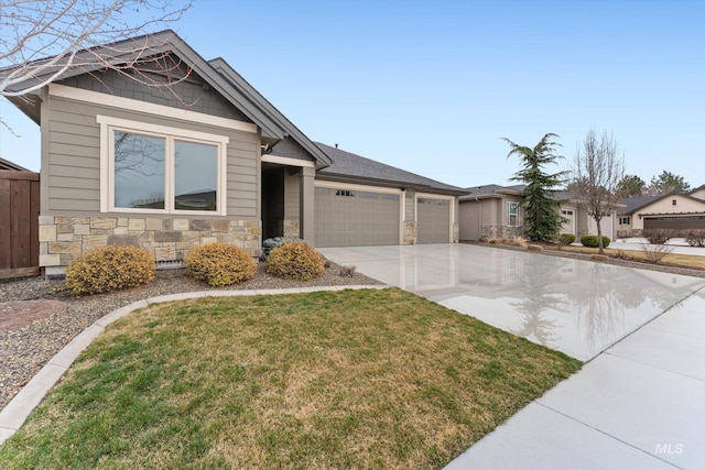 view of front of home featuring a front yard, fence, an attached garage, concrete driveway, and stone siding