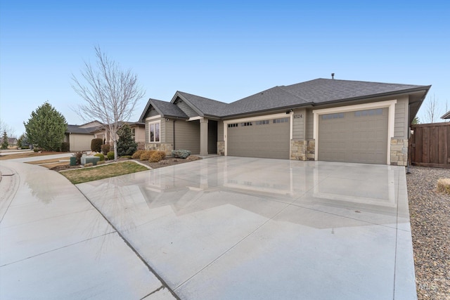 view of front of property with fence, concrete driveway, roof with shingles, stone siding, and an attached garage