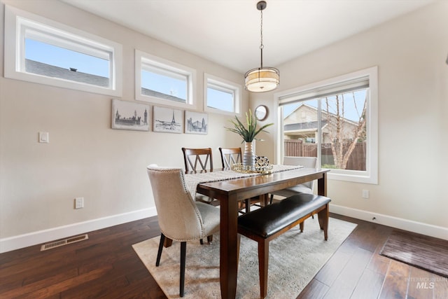 dining space featuring dark wood finished floors, baseboards, and visible vents