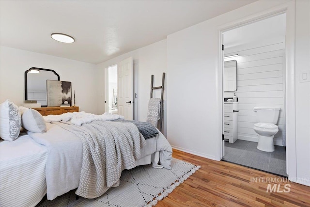 bedroom featuring ensuite bath and light hardwood / wood-style floors