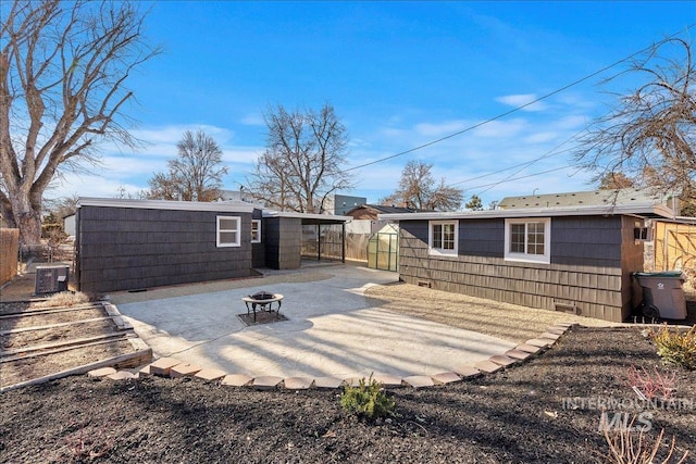 rear view of house with central AC, an outdoor fire pit, and a patio area