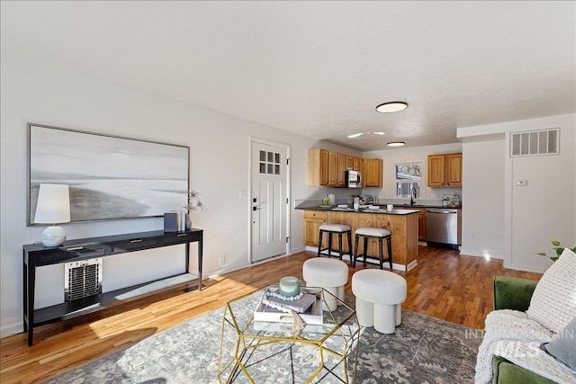 living room featuring sink and dark hardwood / wood-style floors