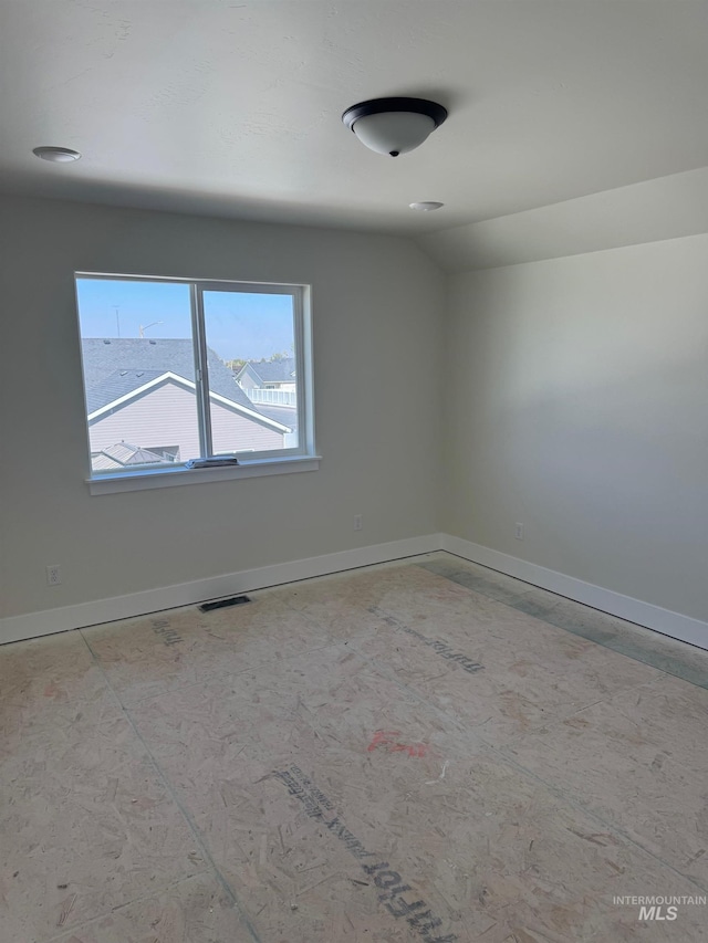 spare room featuring vaulted ceiling