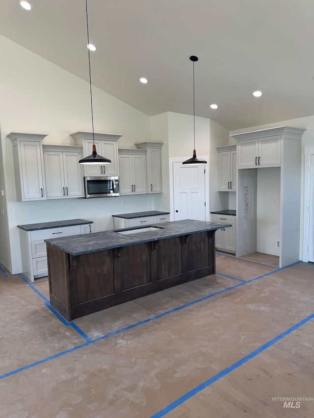 kitchen with decorative light fixtures, a center island, and vaulted ceiling