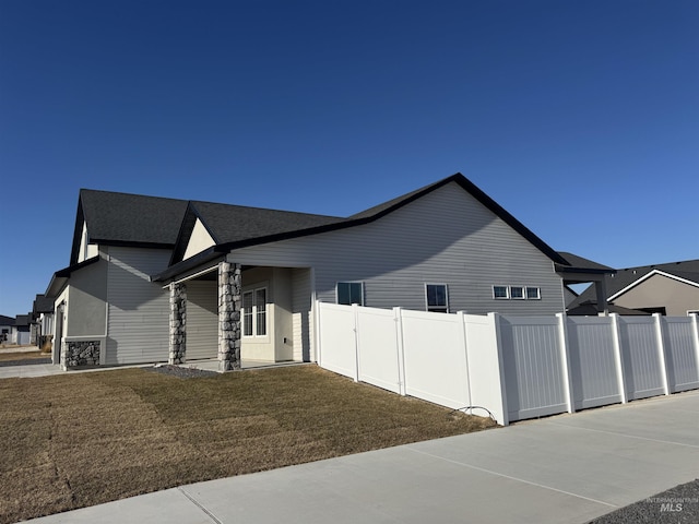 view of side of property with a lawn and fence