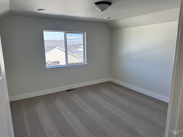 unfurnished room with baseboards, lofted ceiling, visible vents, and carpet