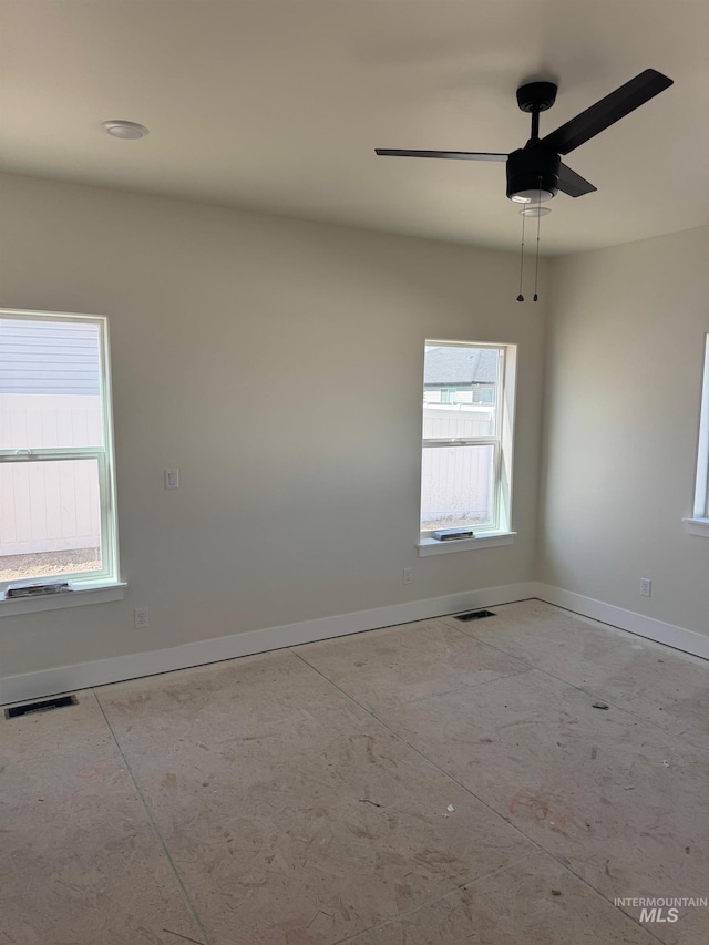 empty room with ceiling fan and a healthy amount of sunlight