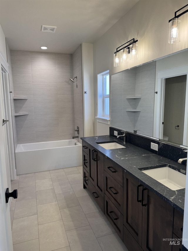 bathroom featuring tile patterned flooring, visible vents, a sink, and double vanity