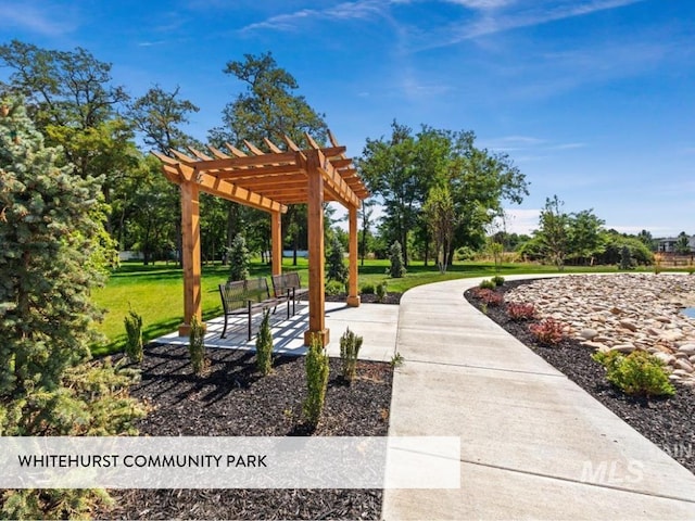 view of community featuring a patio area, a lawn, and a pergola