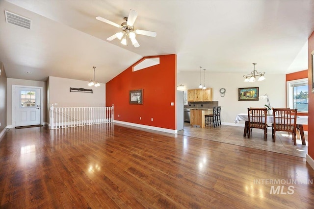 891 N Pointe Dr, Twin Falls, ID 83301 - unfurnished living room featuring a chandelier, baseboards, vaulted ceiling, and healthy amount of natural light
