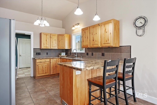 891 N Pointe Dr, Twin Falls, ID 83301 - kitchen featuring freestanding refrigerator, light brown cabinets, a peninsula, a sink, and high vaulted ceiling