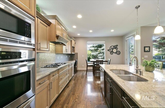448 E Eaglewoods Ln, Eagle, ID 83616 - kitchen with appliances with stainless steel finishes, a sink, backsplash, pendant lighting, and dark wood-type flooring