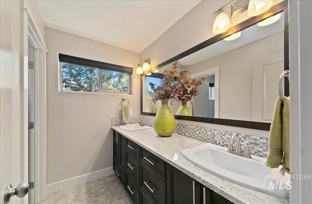 448 E Eaglewoods Ln, Eagle, ID 83616 - bathroom with tasteful backsplash, double vanity, and baseboards