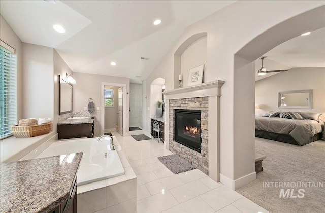 448 E Eaglewoods Ln, Eagle, ID 83616 - ensuite bathroom featuring lofted ceiling, a ceiling fan, a fireplace, a garden tub, and a stall shower