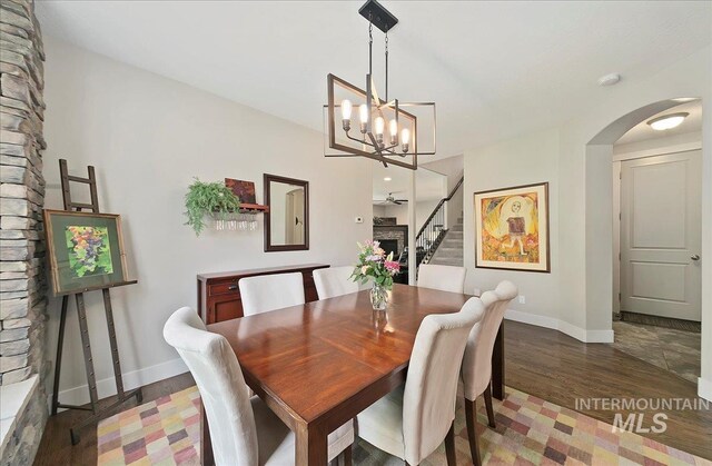 448 E Eaglewoods Ln, Eagle, ID 83616 - dining space featuring arched walkways, baseboards, a chandelier, wood finished floors, and stairway