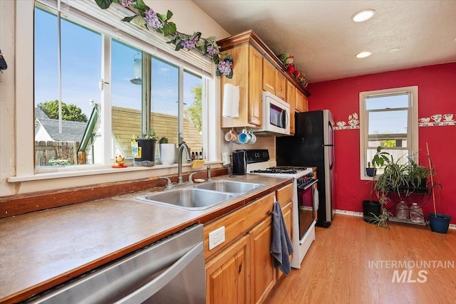129 S Chestnut St, Kimberly, ID 83341 - kitchen with white appliances, a sink, light wood-type flooring, recessed lighting, and brown cabinetry