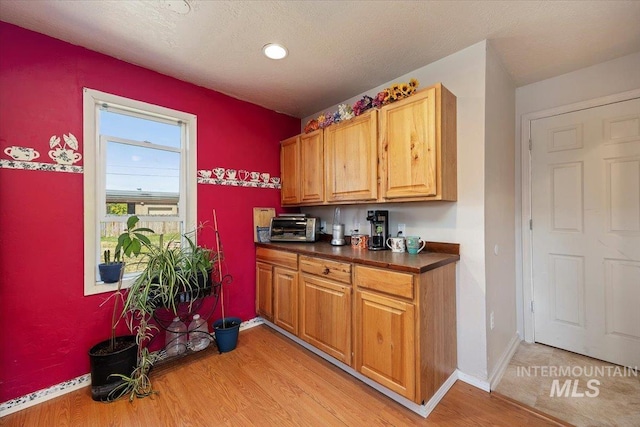 129 S Chestnut St, Kimberly, ID 83341 - kitchen with light wood-style flooring, dark countertops, baseboards, brown cabinetry, and recessed lighting