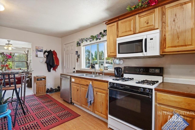 129 S Chestnut St, Kimberly, ID 83341 - kitchen featuring white microwave, gas range oven, stainless steel dishwasher, a sink, and light wood-style flooring