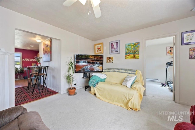 129 S Chestnut St, Kimberly, ID 83341 - living room featuring carpet flooring, a baseboard radiator, ceiling fan, baseboards, and a textured ceiling