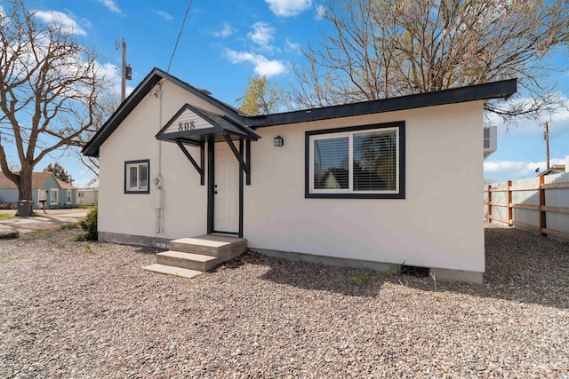 single story home with fence and stucco siding