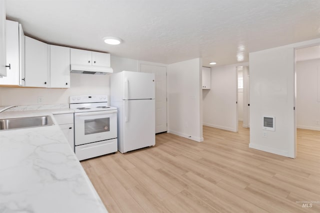 kitchen with under cabinet range hood, white appliances, baseboards, and a sink