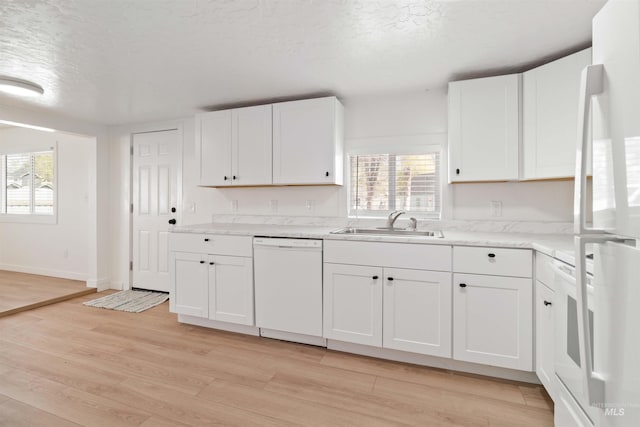 kitchen with white cabinets, a wealth of natural light, white appliances, and a sink
