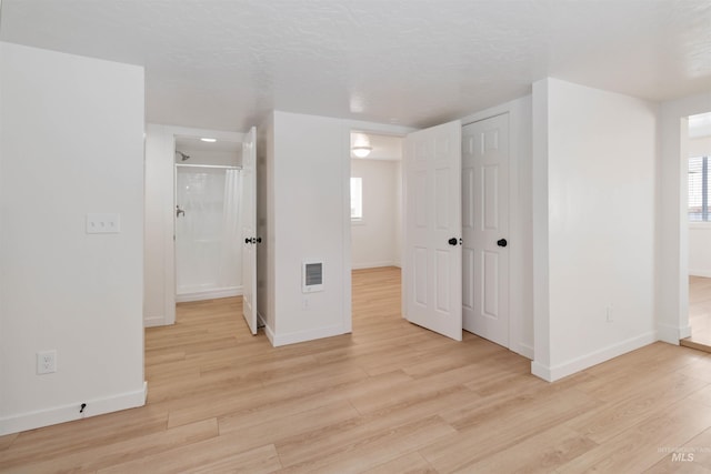 unfurnished bedroom with a closet, light wood-style flooring, baseboards, and visible vents