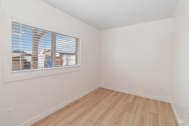 empty room featuring light wood finished floors and baseboards