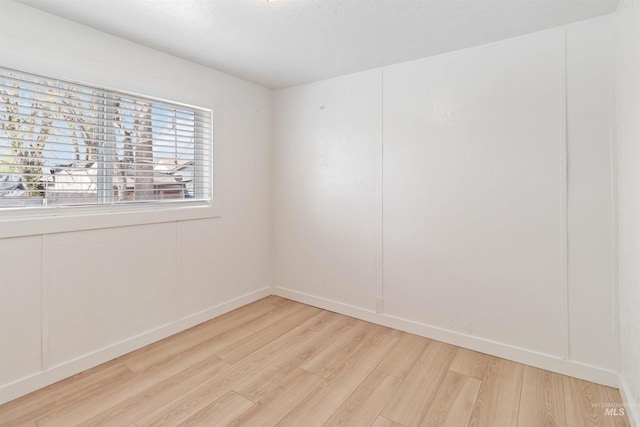 empty room featuring light wood-style flooring and baseboards