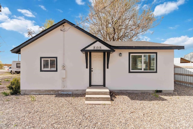 view of front of property with fence and stucco siding