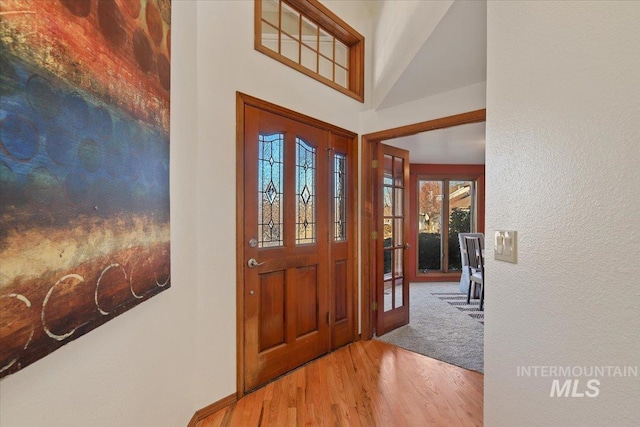 entryway featuring a high ceiling and light hardwood / wood-style floors