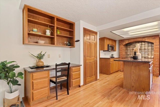 kitchen with a textured ceiling and light wood-type flooring